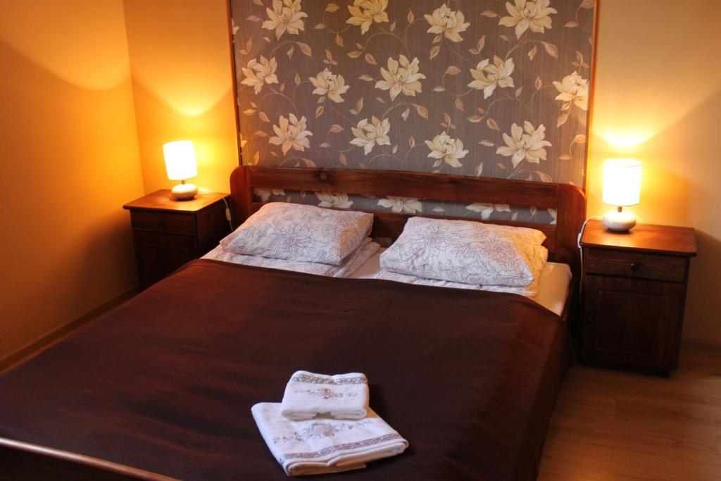 a bedroom with a bed with two towels on it at Domek Na Prowincji in Nałęczów
