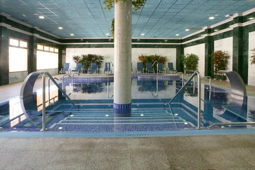 a large swimming pool with a column in a building at Hotel Balneario de la Concepción in Villatoya