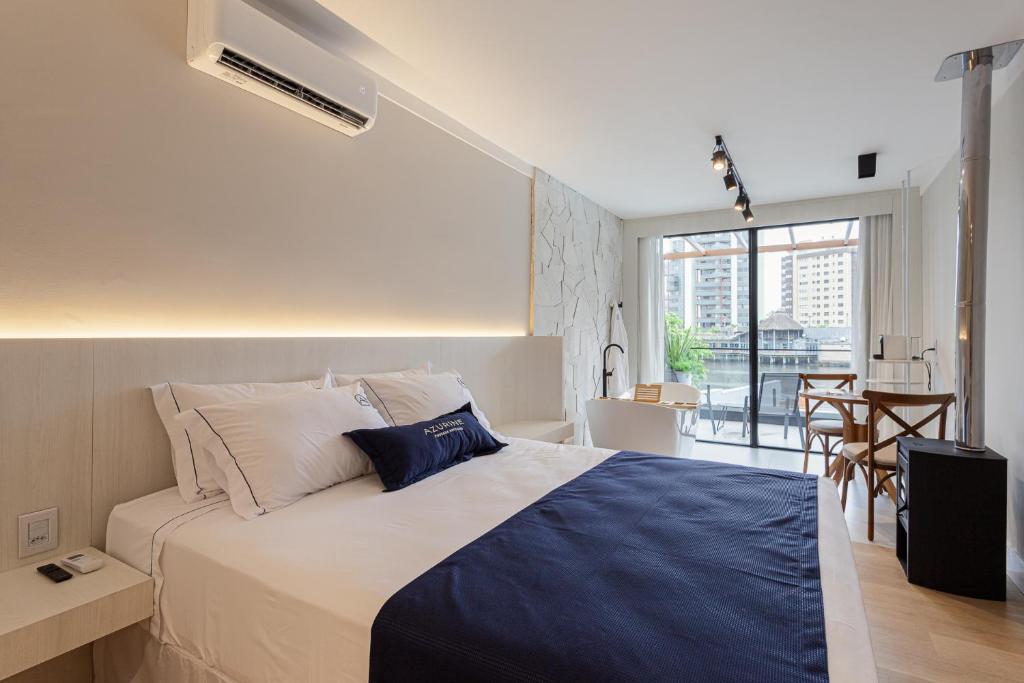 a bedroom with a large bed and a balcony at Azurine Pousada in Passo de Torres