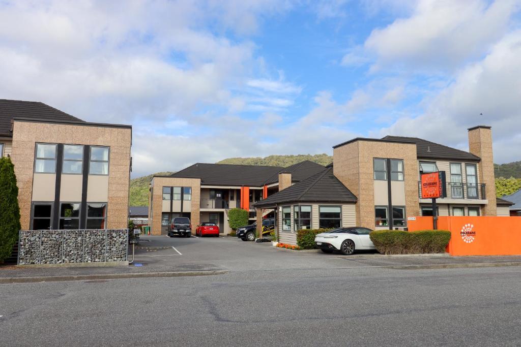 a row of buildings with cars parked in a parking lot at Coleraine Suites & Apartments in Greymouth