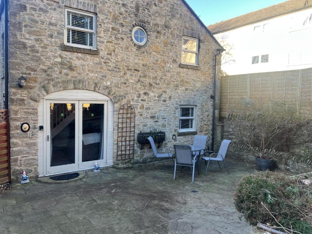 a patio with a table and chairs in front of a building at Honeysuckle Cottage in Richmond