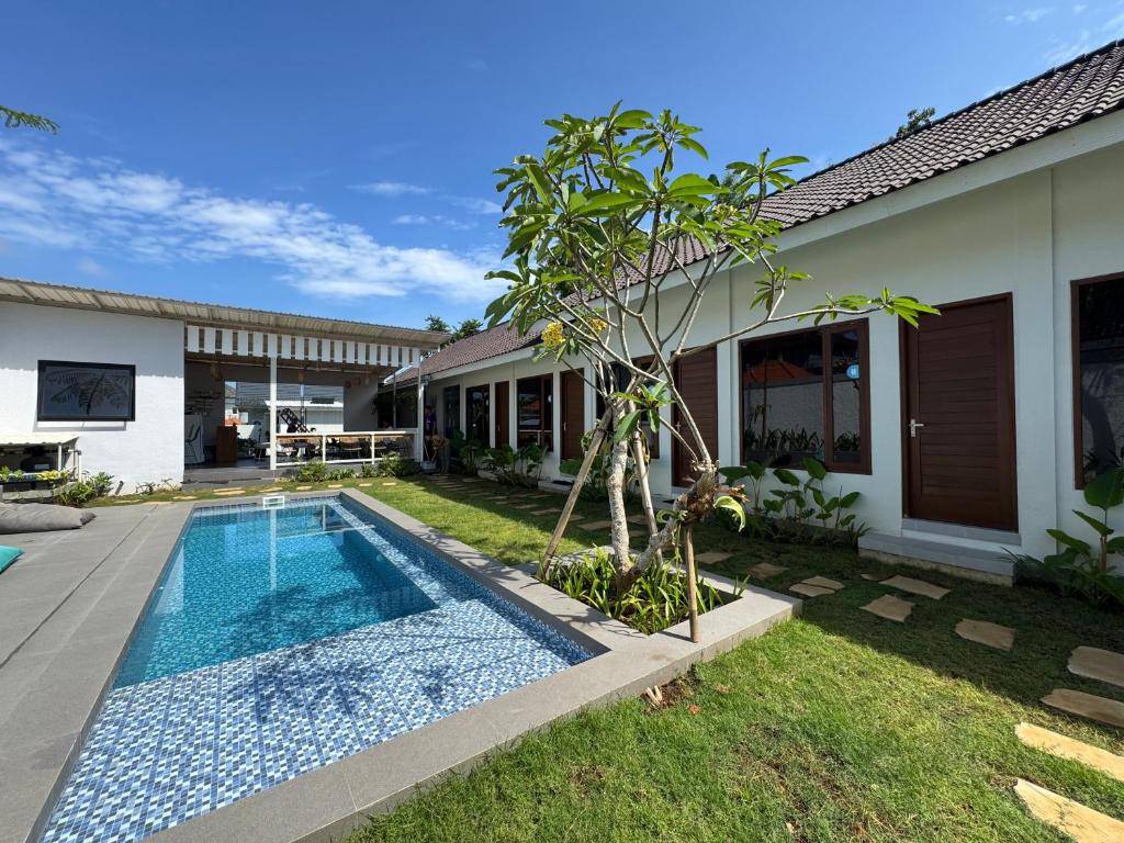 a swimming pool in front of a house at Wish Uluwatu in Uluwatu