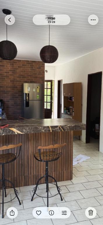 a kitchen with a bar with stools in a room at Temporada Verão in Prado