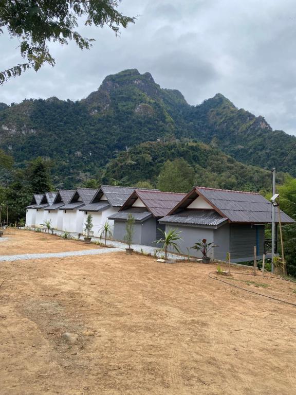 a row of buildings with mountains in the background at Thavisok Guest House in Nongkhiaw