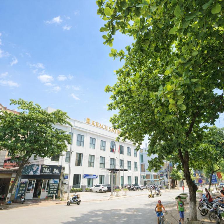 a white building with a tree in front of it at Hoa Hồng Hotel Sơn La in Sơn La