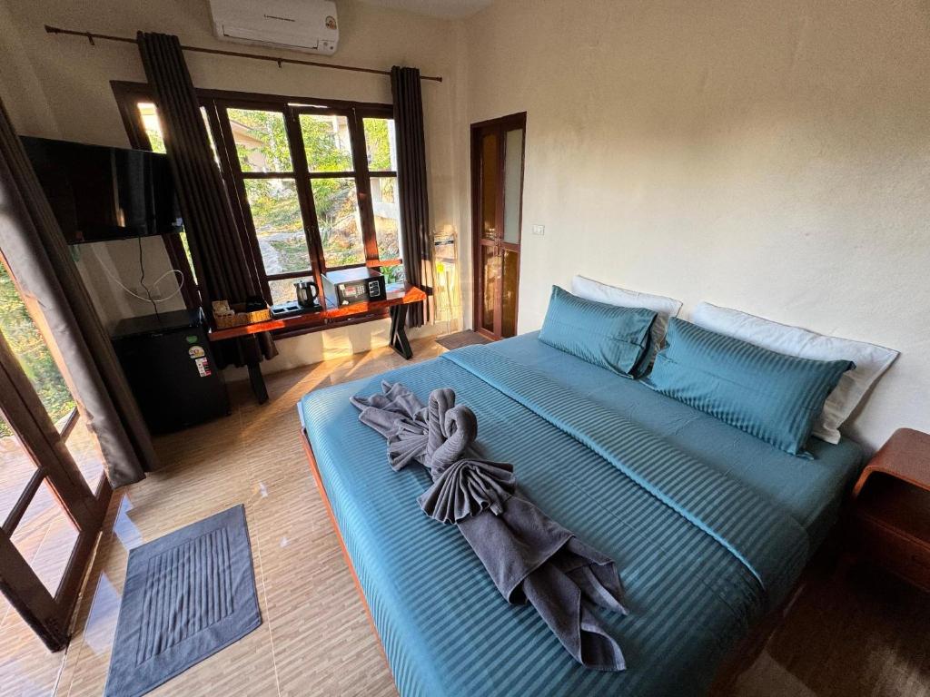 a bedroom with a blue bed with a towel on it at O Zen Resort in Ko Man Nai