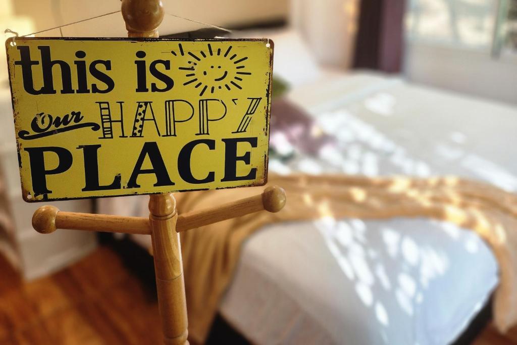 a sign that says this is our happy place next to a bed at Mangrove Beach Houses in Srithanu