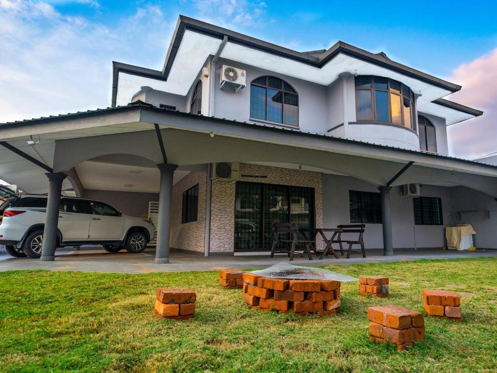 a house with a car parked in front of it at Spacious 4BR Corner with Pool Table in Ipoh