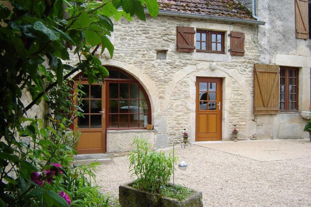 a stone building with brown doors and windows at Relais de la vallée de l'ource in Villars-Montroyer