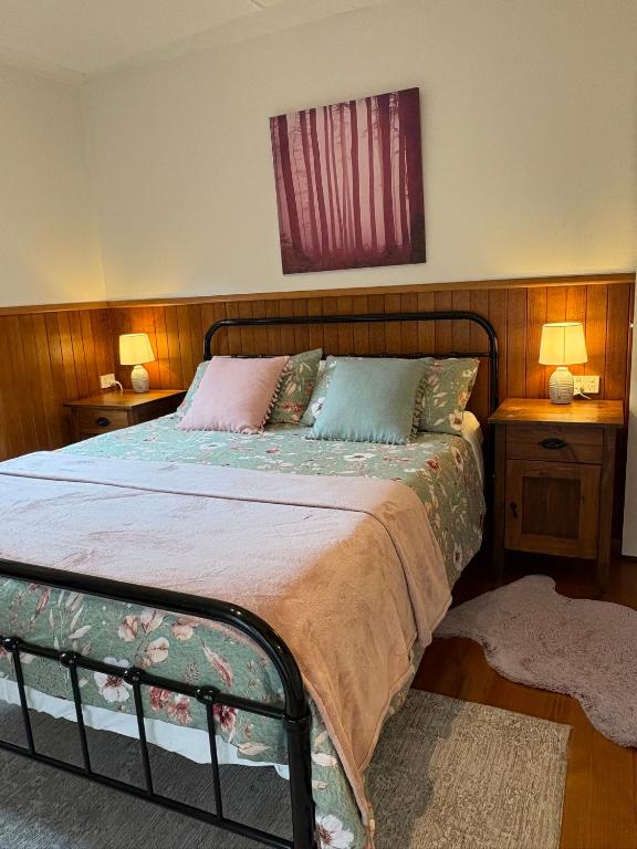 a bedroom with a bed with two night stands and two lamps at The Green Room Wattle Glen in Wattleglen