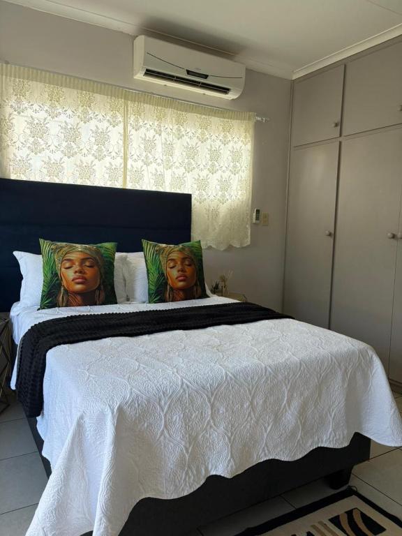 a bedroom with a large bed with two women heads on the pillows at 33 Boeren Guesthouse in Vryheid