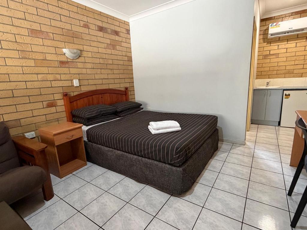 a small bedroom with a bed and a kitchen at The Lodge Village - Workforce Accommodation in Moranbah