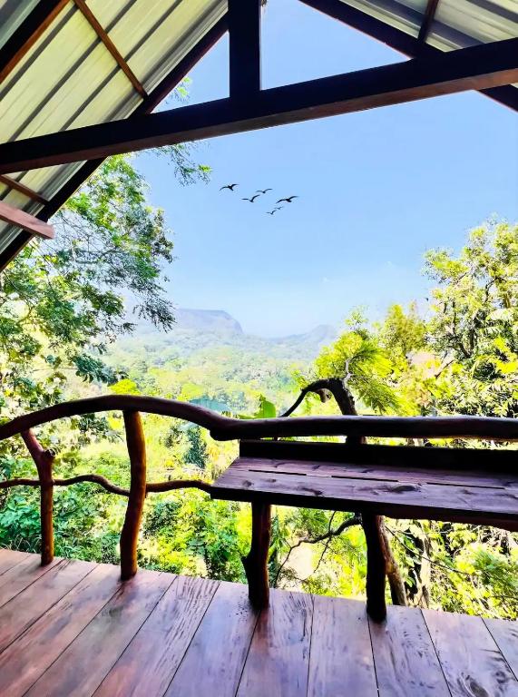 a bench sitting on a wooden deck with a view at Ella Sky Cabana in Ella