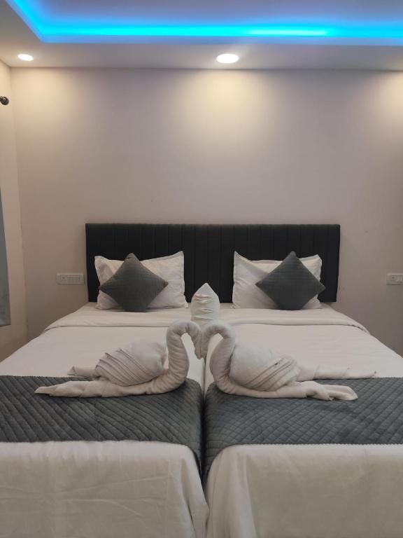 two people in towels are laying on two beds at AERO View Residency in Bangalore