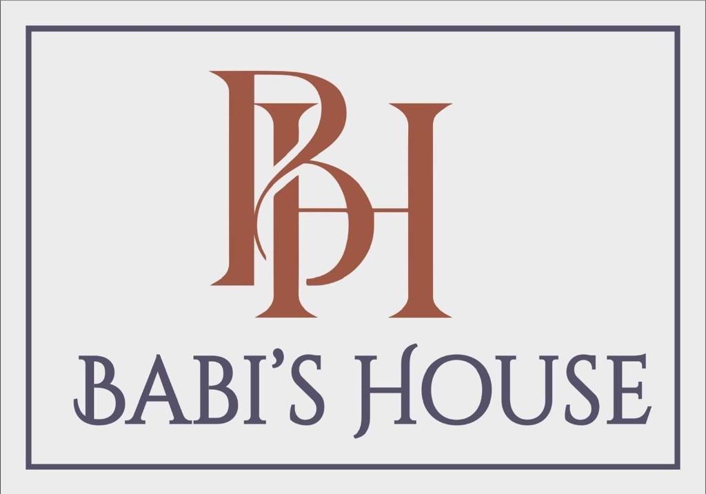 a logo for a barbers house at Babis House in Pelekas