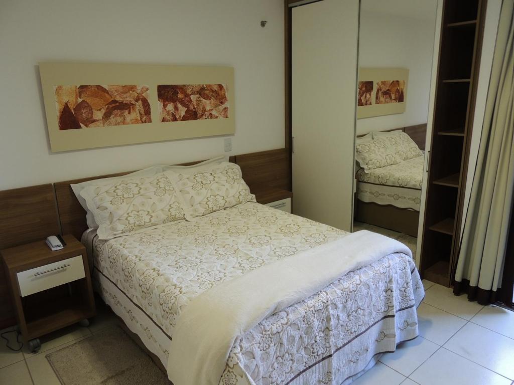 Dormitorio pequeño con cama y espejo en Life Resort, en Brasilia