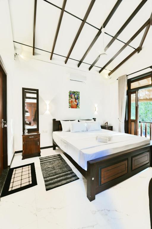 a bedroom with a large bed and a window at Mansion view - Rose Patals in Unawatuna