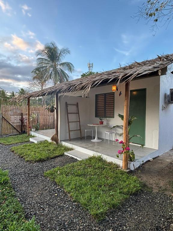 a small white house with a table and chairs at Garden Village in El Nido