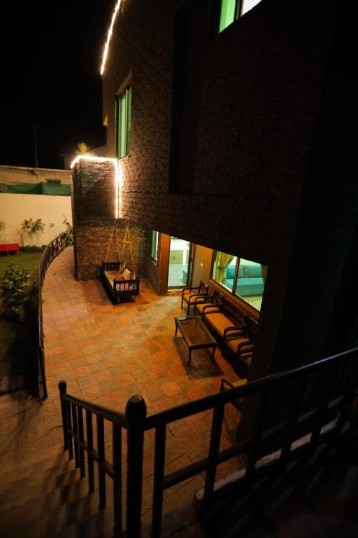 a group of benches sitting on a patio at night at Sardar Villa NathiGalli in Bāzār