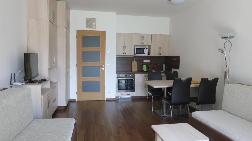 un soggiorno con cucina, tavolo e sedie di Apartment Medvědín 87 a Špindlerův Mlýn