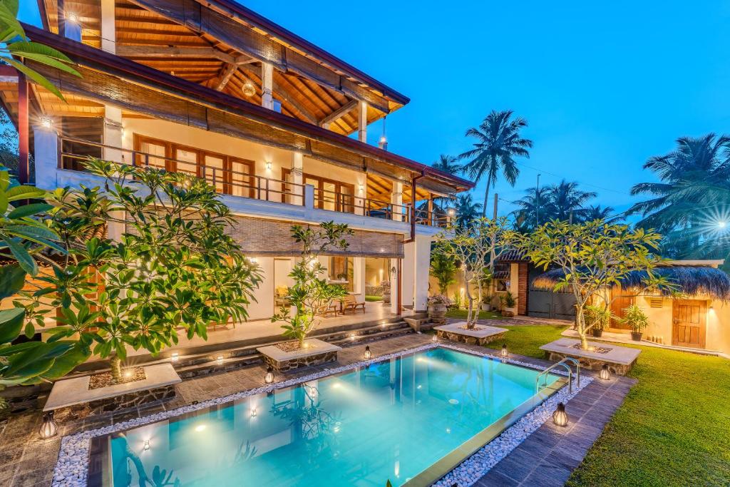 an exterior view of a house with a swimming pool at OMA Hikkaduwa in Hikkaduwa