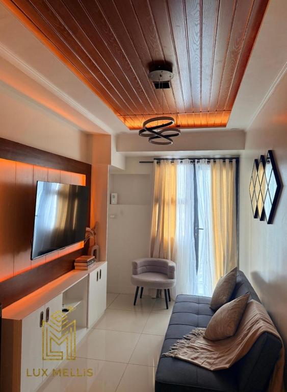 a living room with a blue couch and a television at Sophisticated 1BR Unit w Panoramic Horizon View in Cebu City