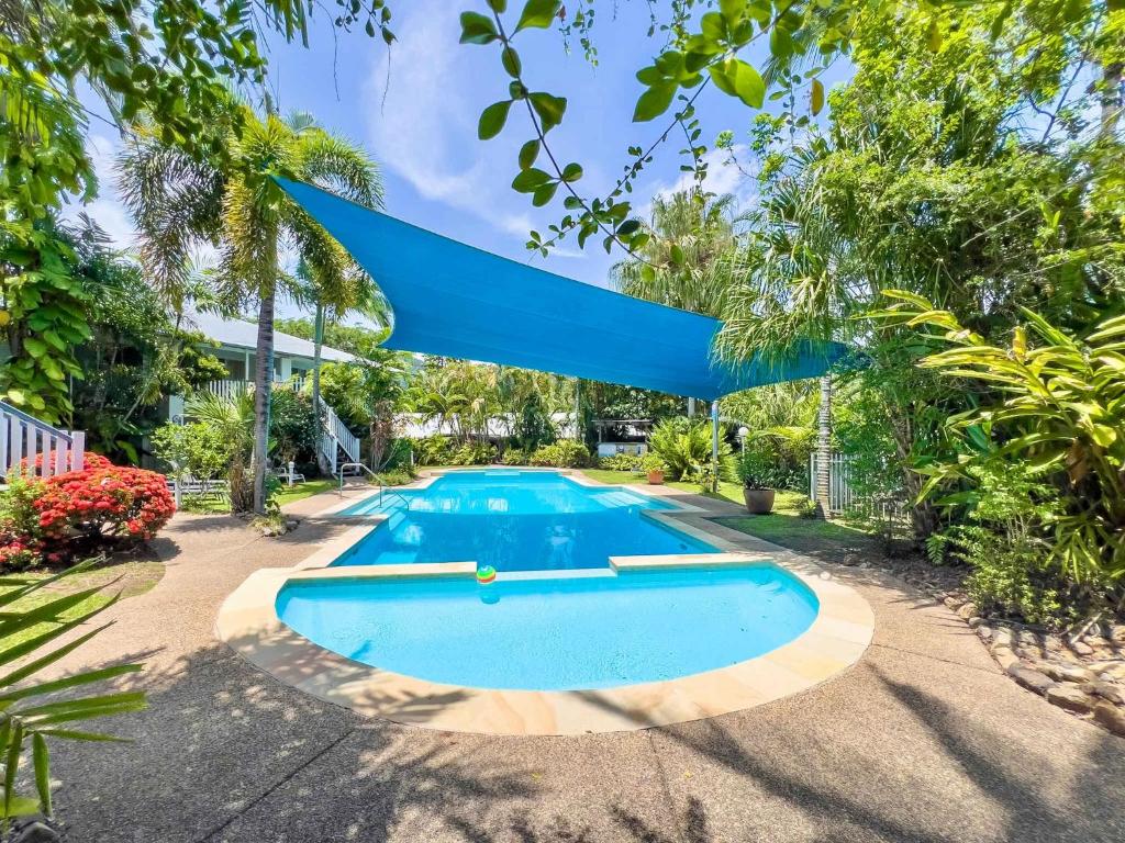 an image of a swimming pool in a yard with trees at Mango Palms in Airlie Beach