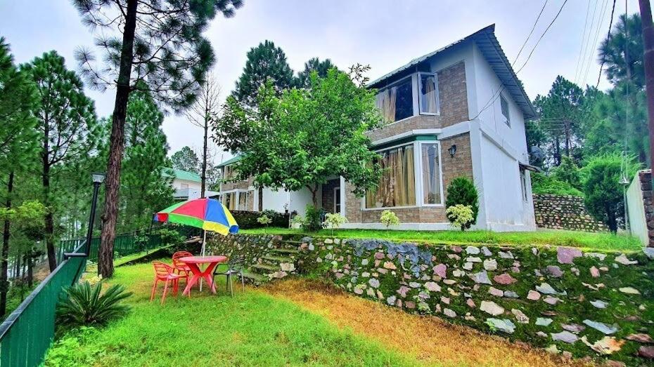 a house with a table and a colorful umbrella at Blue Pine Orchards in Lansdowne