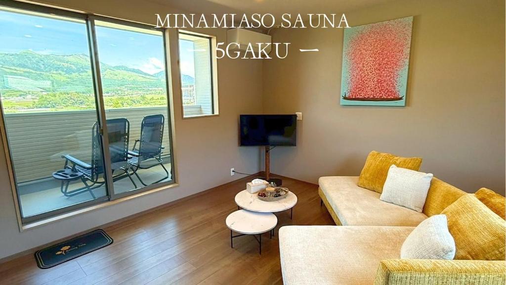 a living room with a couch and a table at 南阿蘇サウナ5gaku G4 in Minami Aso
