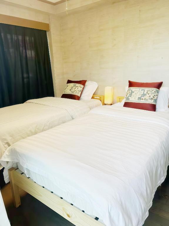 two beds sitting next to each other in a room at 烟雨轩 303 in Tokyo