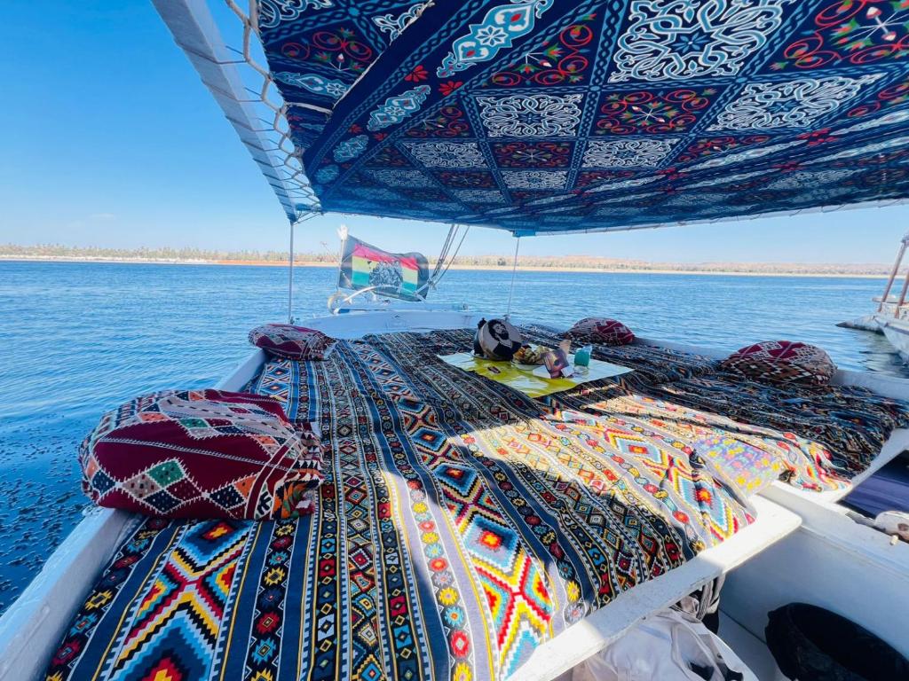 a boat with a cat sleeping on a blanket on the deck at Aswan all-inclusive private felucca in Aswan