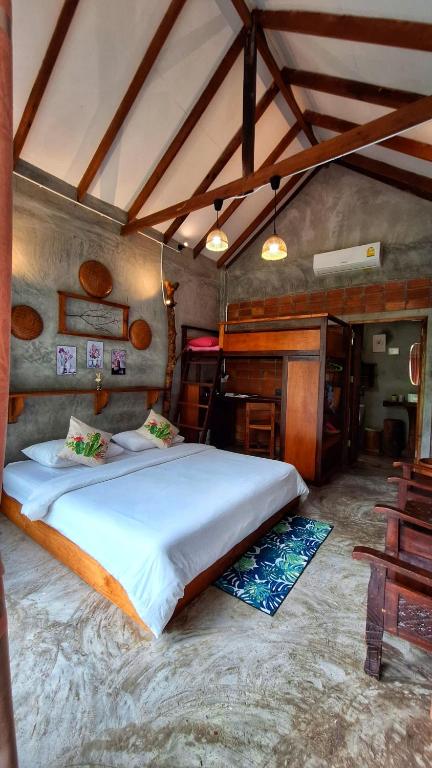 a bedroom with a large bed in a room at BaanRaiChayKhaoFarmStay in Nakhon Si Thammarat