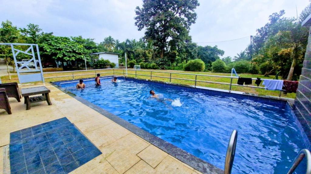 a group of people in a swimming pool at Serene Blossom Valley in Tenkāsi