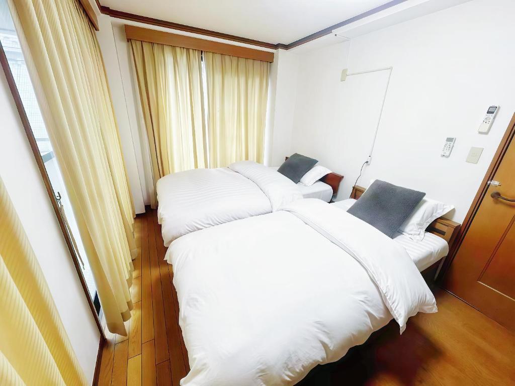 a bedroom with two beds with white pillows at 烟雨轩 203 in Tokyo