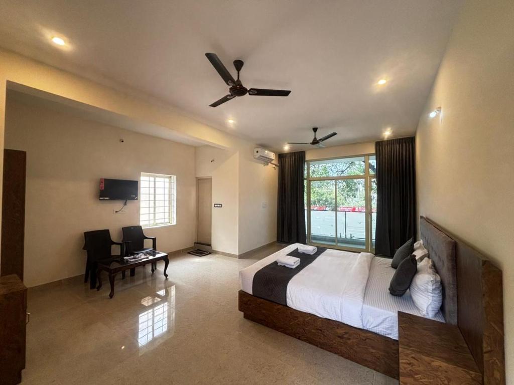 a bedroom with a bed and a ceiling fan at Surabhi Comforts Inn in Mysore