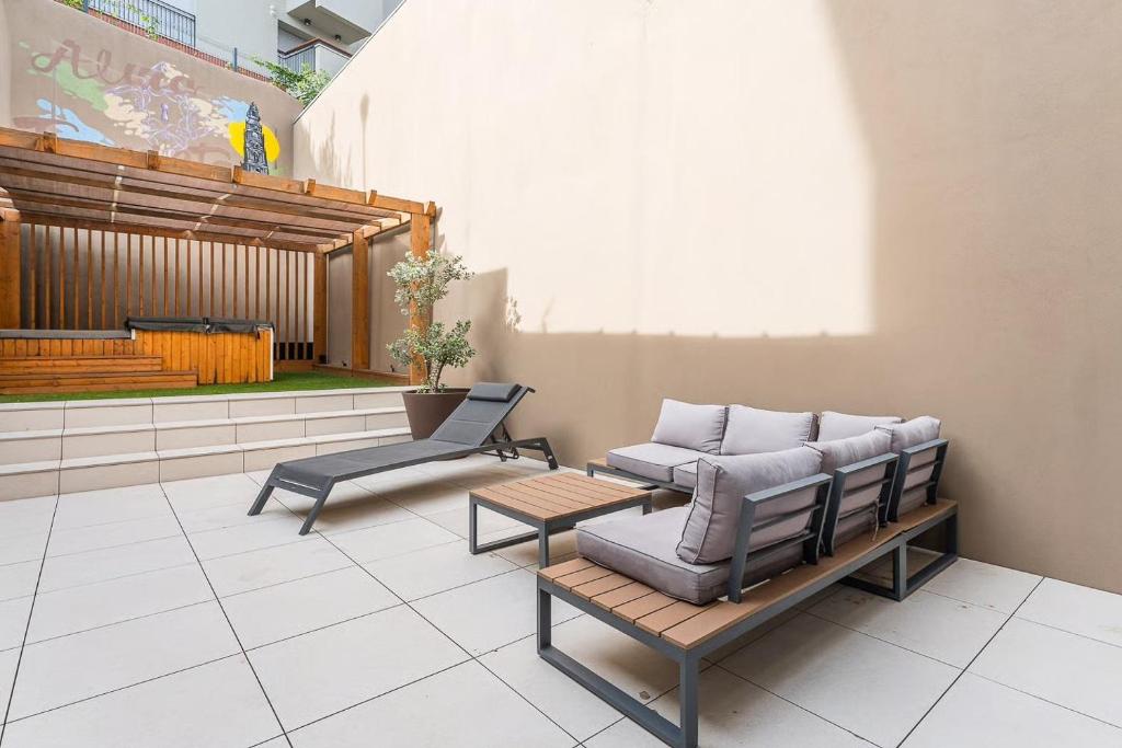 a patio with two chairs and a couch and a table at GuestReady - Alma Invicta in Porto