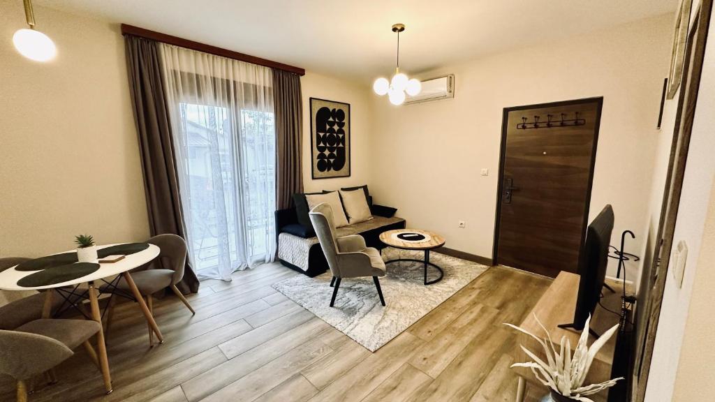 a living room with a table and chairs and a television at Central Station Apartments in Podgorica