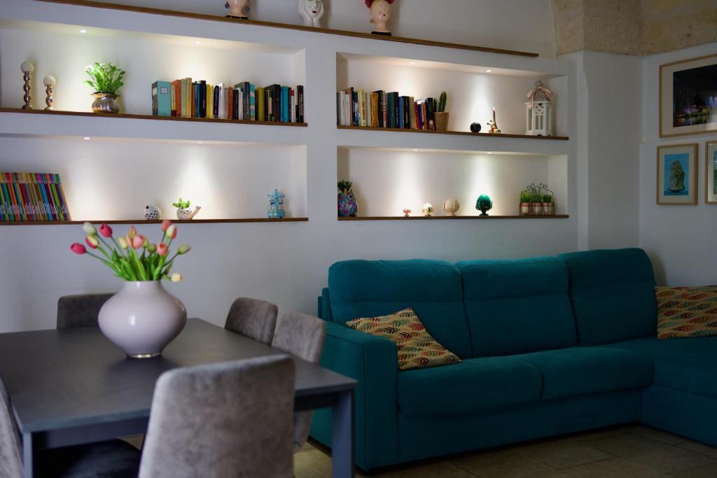 a living room with a blue couch and a table at Dimora Imperiali in Francavilla Fontana