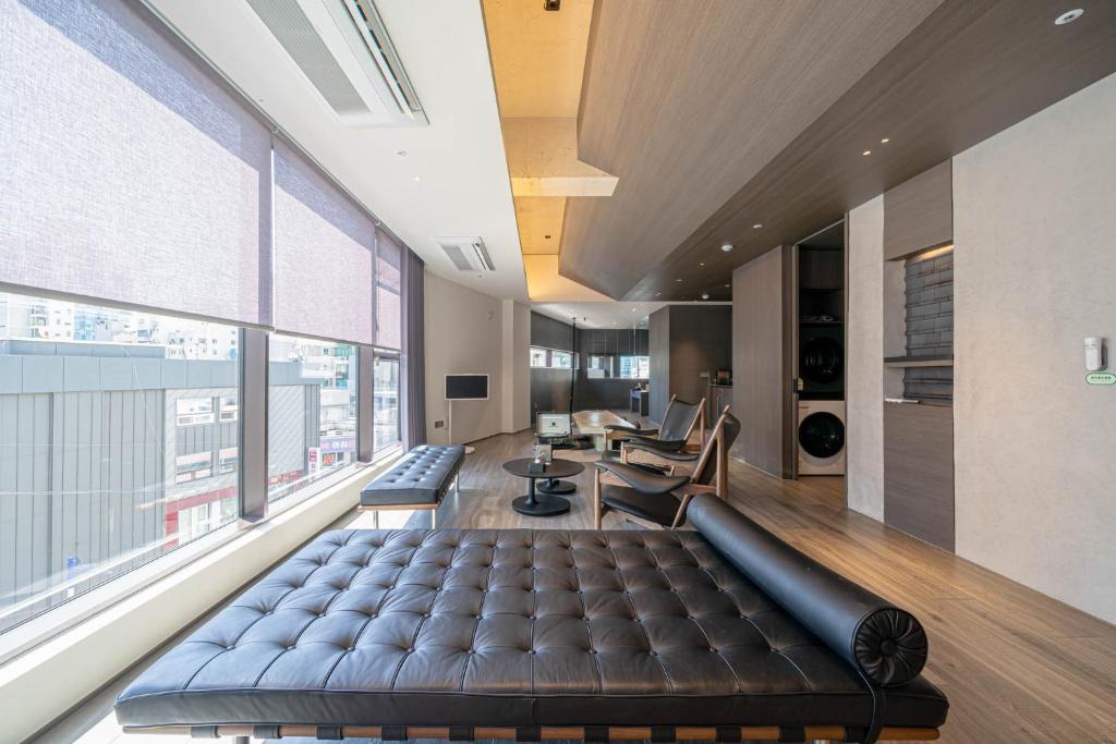 a large leather couch in a room with a large window at The Moor Wellnsee Pool Villa in Busan