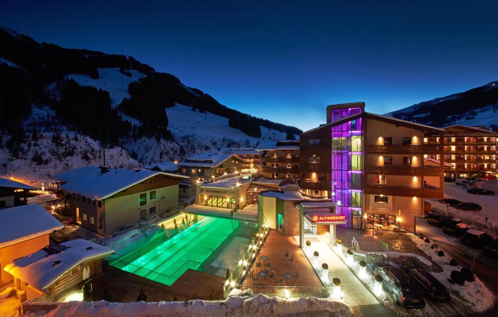 a hotel with a swimming pool at night at Alpinresort ValSaa - Sport & Spa in Saalbach-Hinterglemm