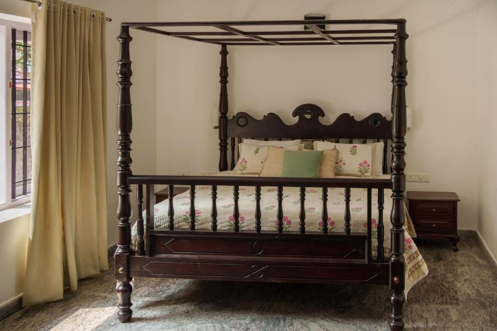 an ornate black bed in a bedroom at Orma in Cochin