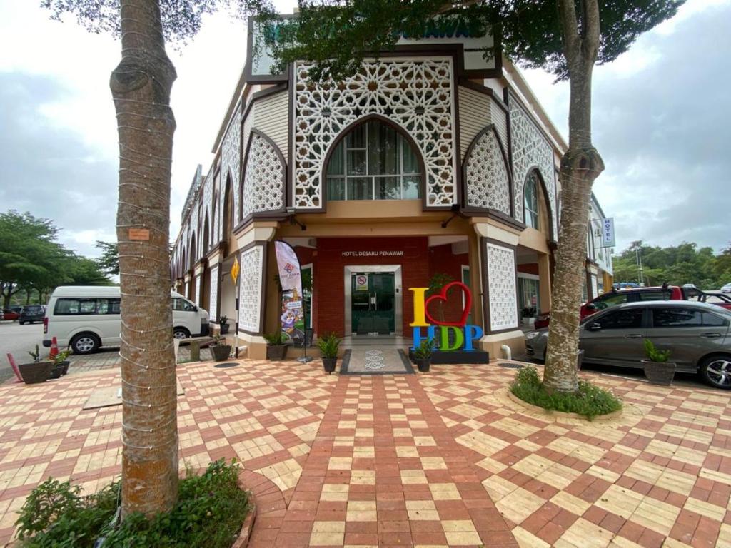 a building with cars parked in front of it at Hotel Desaru Penawar in Desaru