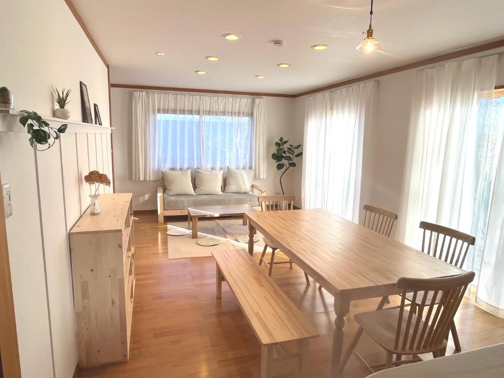 a living room with a table and a couch at Cozy House Azumino in Azumino