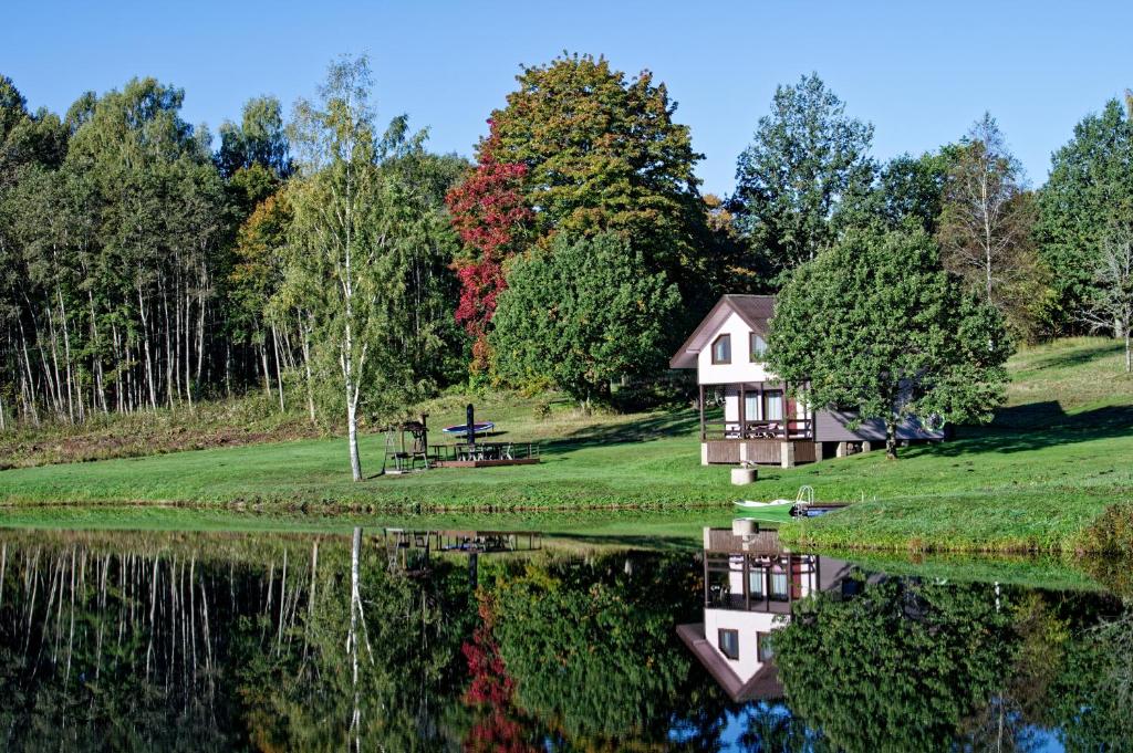 a house on the shore of a lake at Atpūtas vieta Upes Sausītes in Sidrabiņi