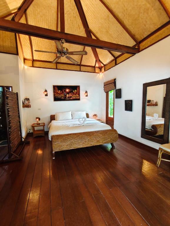 a bedroom with a bed and a ceiling fan at Private Balinese Bungalow for 2 - Shared pool - Lamai Koh Samui in Nathon Bay