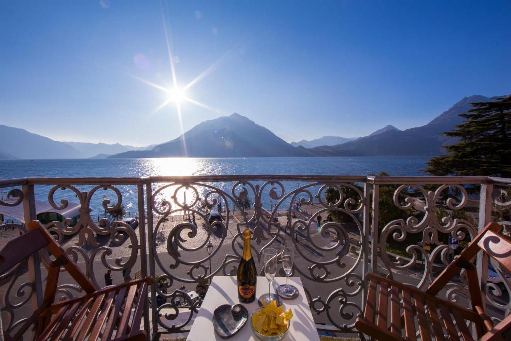 a balcony with a table with a bottle of wine at Bella Varenna in Varenna