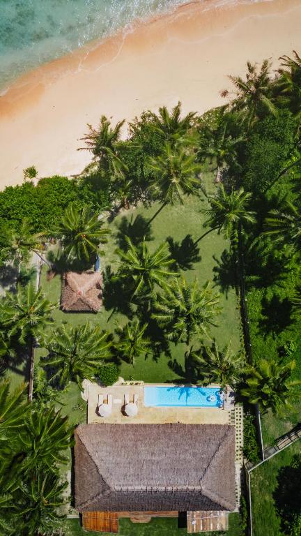 an aerial view of a resort with a pool and palm trees at Villa Madu Mentawai in Katiet