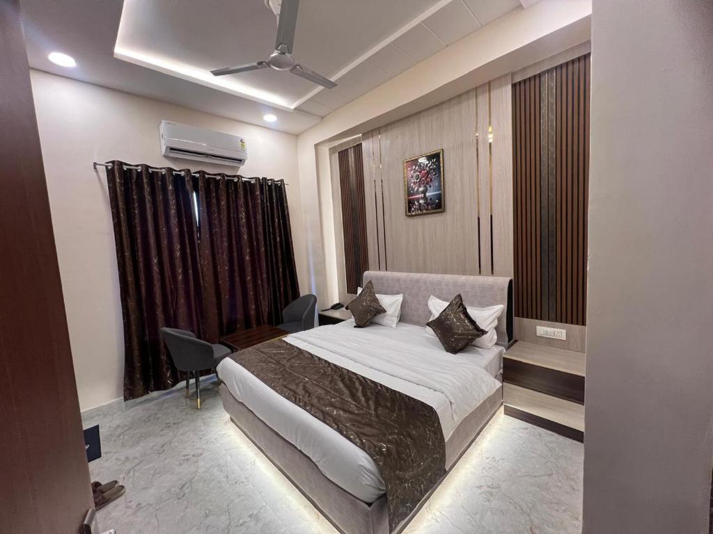 a bedroom with a bed and a chair in it at Hotel Highway Retreat in Gajraula