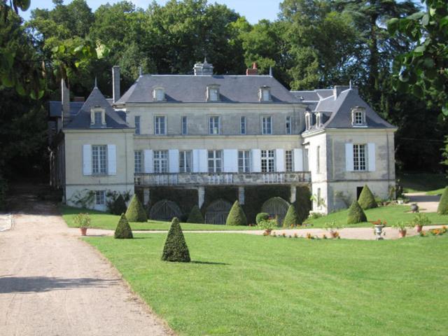 ein großes weißes Haus mit Rasen davor in der Unterkunft Chambres d'Hôtes Le Château de la Plante in Thuré