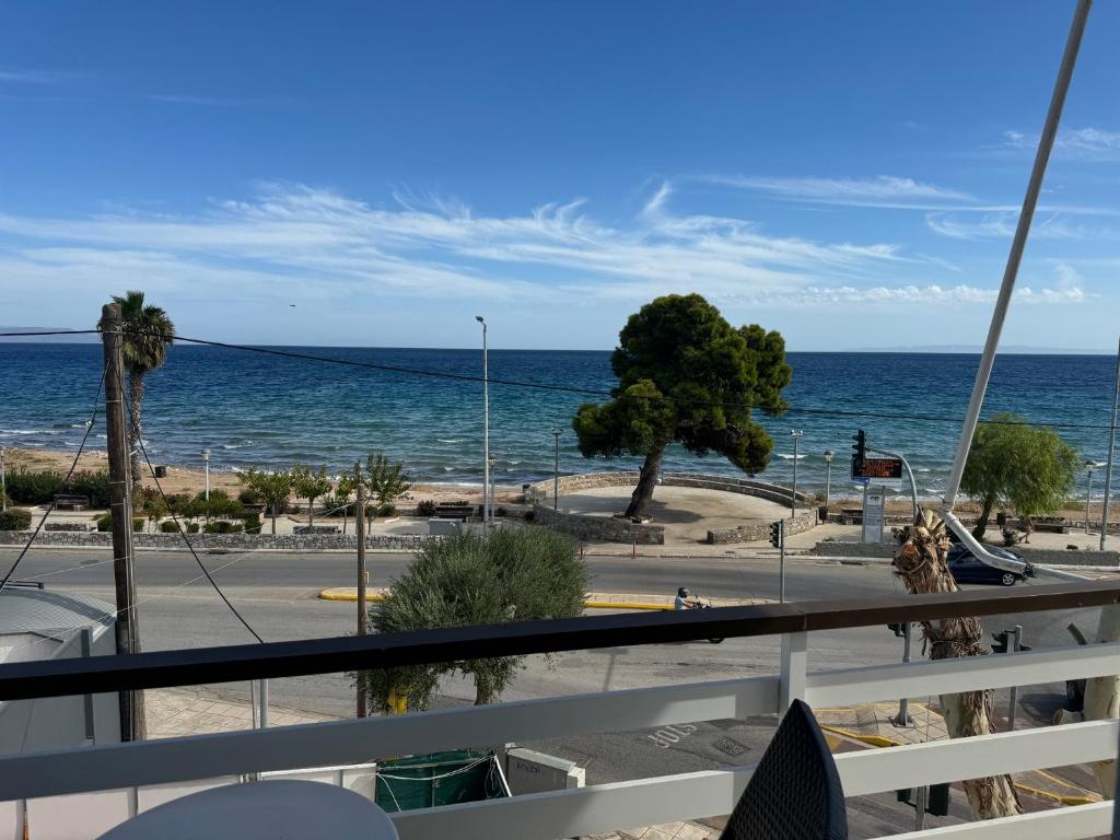 a view of the ocean from a balcony at Starfish Airport Apartment in Artemida